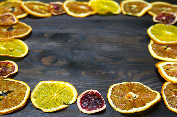木制背景上的干橙子和柠檬的果实。