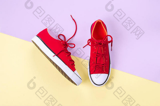 黄色和紫罗兰色背景的新红色运动鞋，带有空间。
