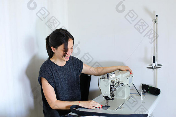 女裁缝用缝纫机缝制皮带。
