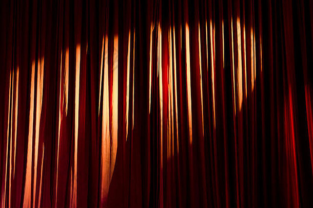 红色的窗帘和舞台上的聚光灯。