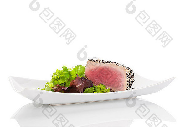 美味的金鱼牛排配上新鲜的绿色沙拉，放在白色的盘子里，背景是白色的。烹饪海鲜。