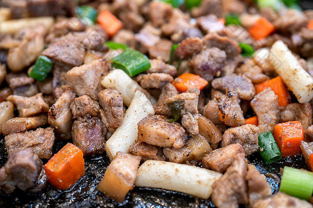 <strong>韩国</strong>传统市场上的油炸黑猪肉，美味的<strong>韩国</strong>美食，胡萝卜和葱，特写，空间