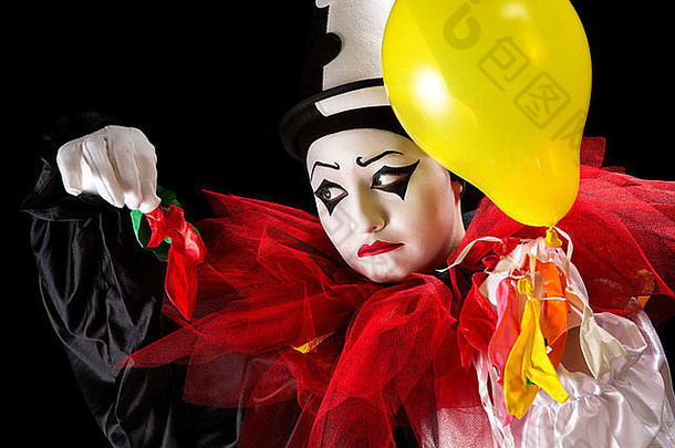 悲伤的皮耶罗小丑拿着他剩下的气球