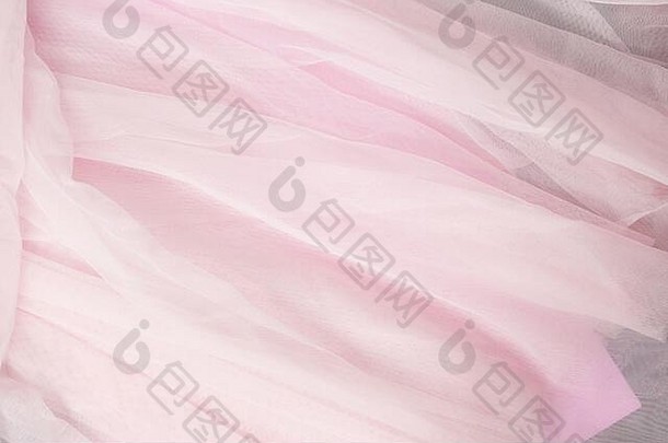 柔软的粉红色珊瑚色米色薄纱背景。婚纱，织物质地
