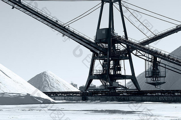 白盐山堆积着一台大型工业机器在轨道上移动。黑白照片