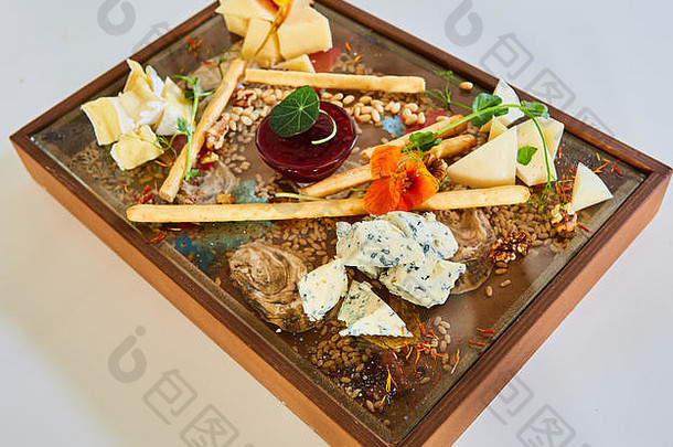 奶酪选择在木制质朴板上。在木头上放着不同奶酪的奶酪拼盘。