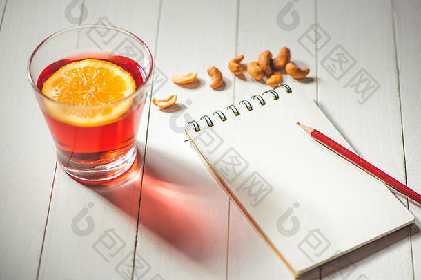 一杯热的圣诞饮料。用橘子和笔记本煮酒，并在笔记本上留有文字空间。