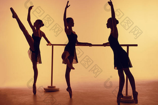 三名年轻芭蕾舞演员在橙色背景下的剪影构成。