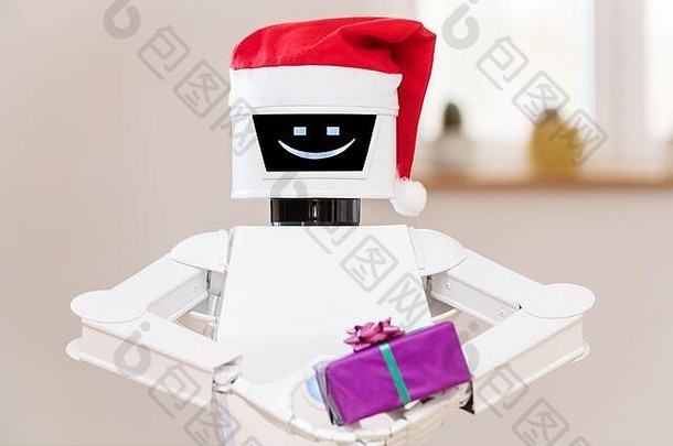 头戴红色圣诞帽的环境<strong>辅助生活</strong>或aal机器人手里拿着一份礼物。白色服务机器人的肖像