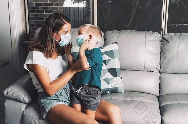 在冠状病毒和流感爆发期间，母亲和孩子在家里戴口罩。病毒防护。母亲和儿子试图阻止疾病传播。
