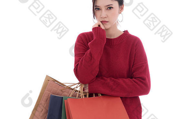 年轻的女人思考持有购物袋孤立的白色背景