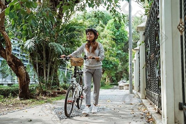 美丽的年轻女子骑着折叠自行车行走