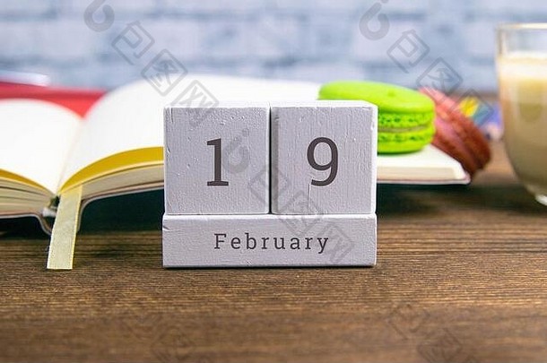 2月19日在木制日历上。冬季月份的第十九天，工作场所的日历。冬天