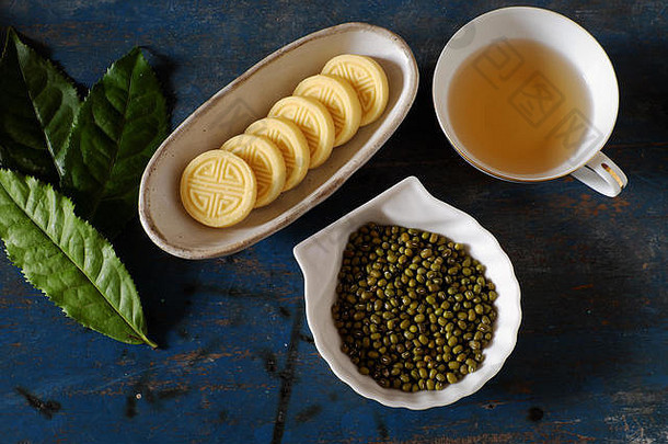 越南甜蜜的食物绿色豆子蛋糕绿色小扁豆传统的食物茶时间板食物杯茶木背景