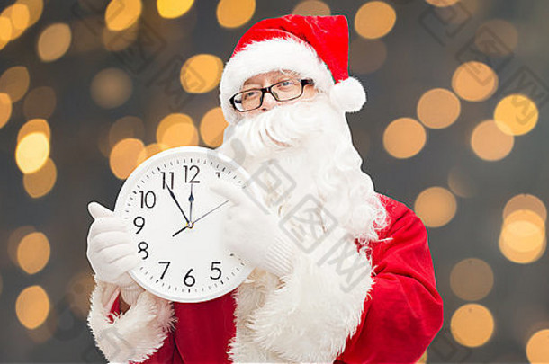 穿着圣诞老人服装，戴着钟的男人