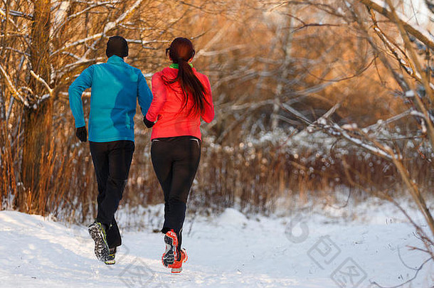 图片来源于冬季跑步的男女运动员的背部