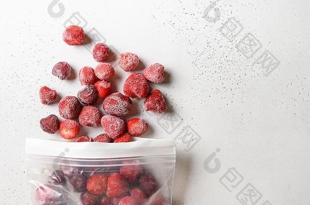 白色塑料袋中的冷冻草莓。从上面看。