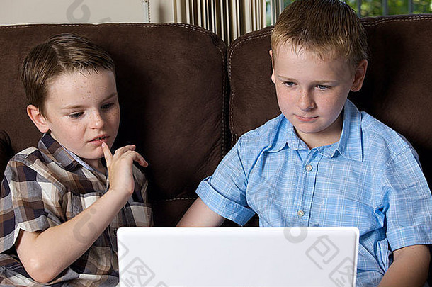 两兄弟在家使用笔记本电脑