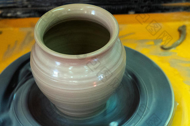 关于用陶工的轮子制作陶瓷壶的硕士班。陶器正在绕轴线旋转。