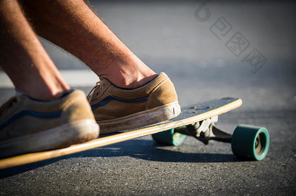 特写镜头：一个滑板手在街上滑行