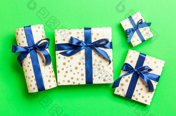 用绿色<strong>背景</strong>上的蓝丝带用纸包装圣诞或其他节日手工礼品。礼品盒，彩<strong>台</strong>礼品装饰，t