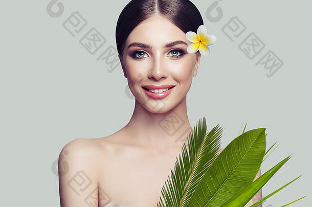水疗中心女人健康的皮肤可爱的微笑热带叶子花白色背景水疗中心美美容概念