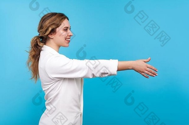 欢迎侧面图：友好好客的女商人，扎着马尾辫，身穿白色夹克，手拉手握手，问候合作伙伴，看起来很社交