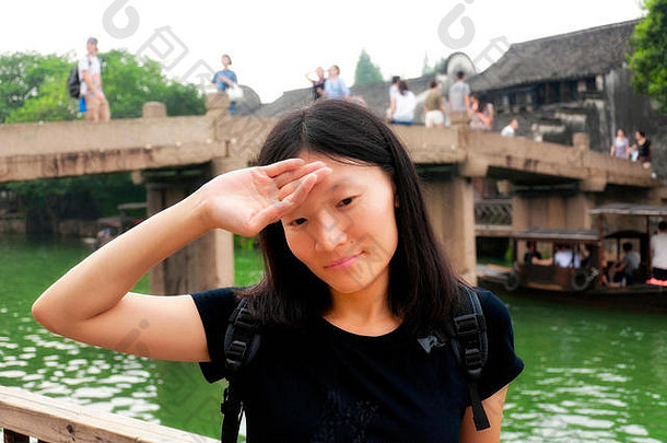 中国浙江省桐乡乌镇风景区的水渠附近，一名中国妇女举着她的头。