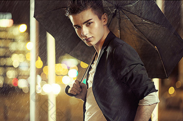 带着黑色雨伞的迷人年轻模特