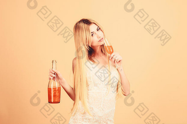 女人拿着一杯酒精饮料。迷人的女士喜欢桃橙利口酒。开胃酒概念。豪华酒。酒吧餐厅。俱乐部和成人酒会。喝珍珠香槟的女孩。