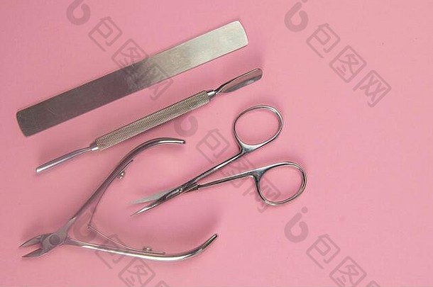 修指甲剪、锯子、指甲袋，以及位于粉红色背景上的表皮切割工具