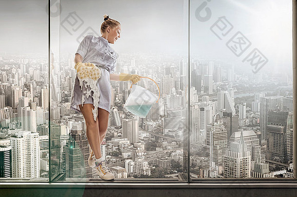 大城市背景下年轻酒店服务员洗玻璃的画像