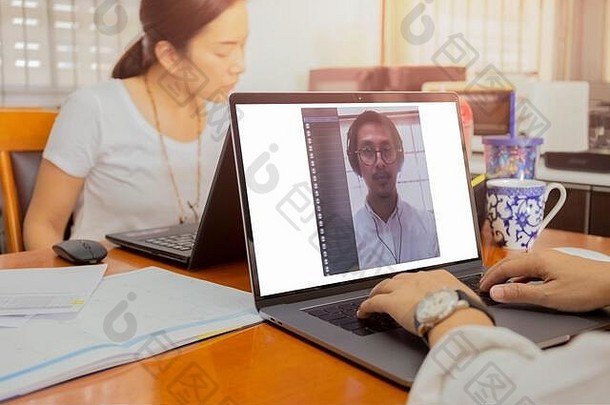 商人使用笔记本电脑2019冠状病毒疾病视频会议。