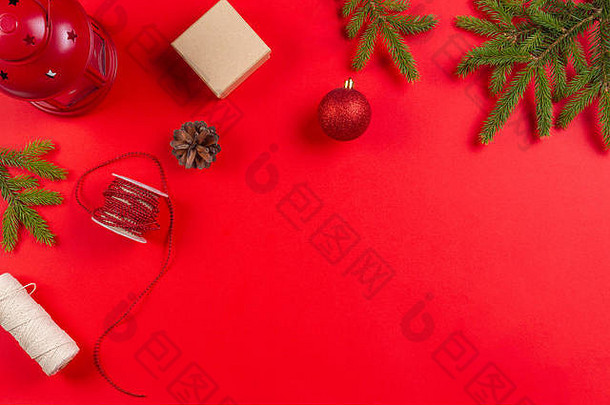 <strong>圣诞</strong>礼物包装。红色背景上的冷杉树枝、松果和礼品盒