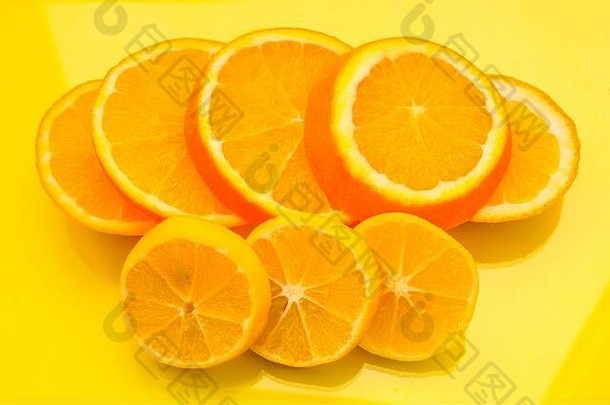 黄色背景上的橙色和柠檬片-库存照片