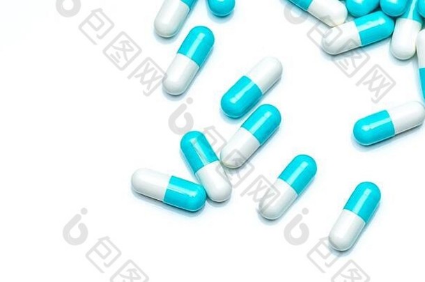 在白色背景上分离的蓝白色胶囊药丸。医药行业与药品市场概念。蓝色粉彩胶囊药丸的俯视图