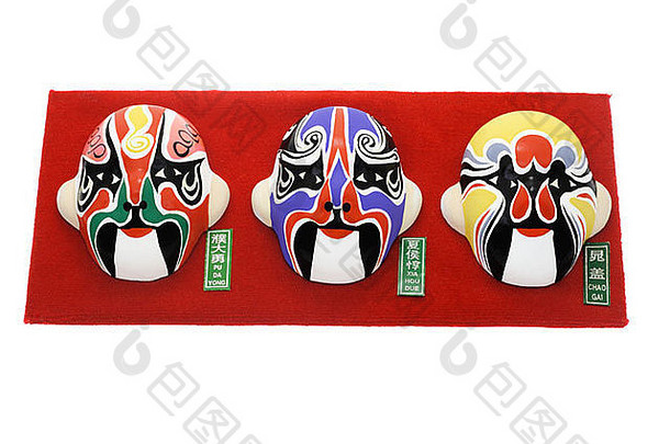 红色背景上的三个中国京剧面具饰物与白色背景隔离