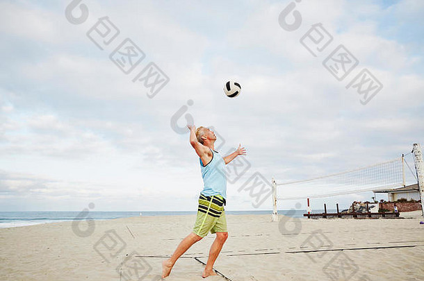 成熟的男人。站海滩玩海滩排球