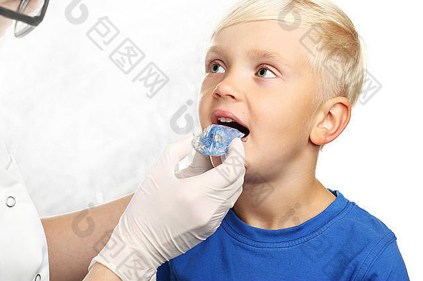 先戴牙套，把正畸医生的孩子交给医生。戴牙套的小男孩
