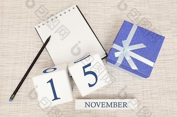 11月15<strong>日</strong>的记事本和木制<strong>日</strong>历，旁边是一个蓝色礼品盒。