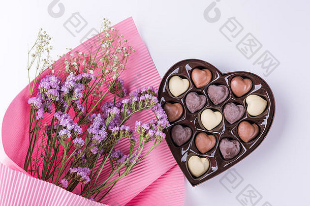 白色背景上有心形巧克力盒的美丽花朵