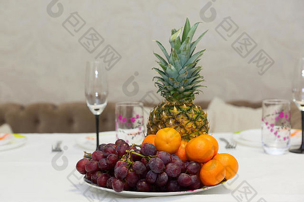 节日餐桌上的葡萄菠萝和橘子
