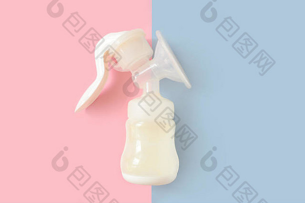 母乳泵为新生儿提供的奶瓶，背景颜色为粉色和蓝色。妇幼保健概念。女孩或男孩。顶视图。
