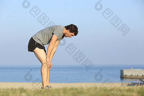 疲惫跑步者<strong>男</strong>人。休息海滩锻炼海洋背景