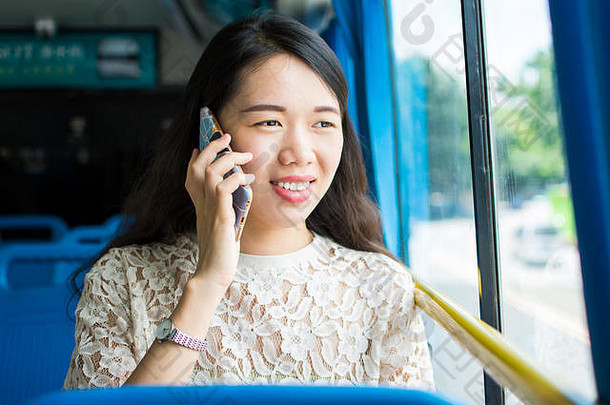 亚洲女孩在<strong>公交车上</strong>使用手机
