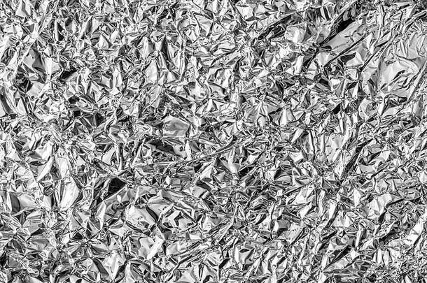 皱巴巴的厨房铝箔的纹理。银色抽象设计背景。