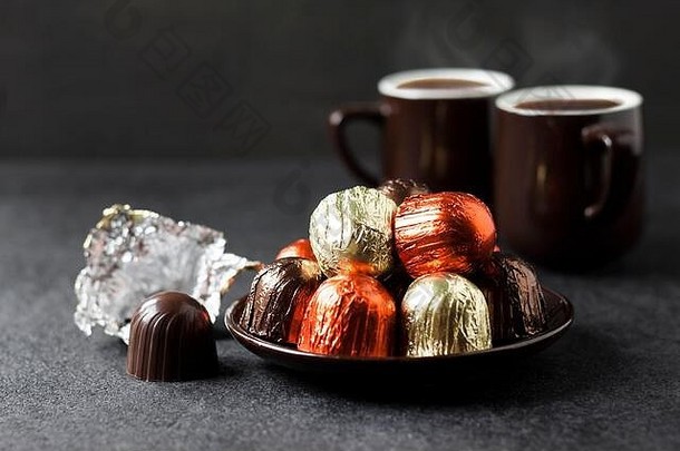 巧克力糖果包装五彩缤纷的箔杯咖啡黑色的背景