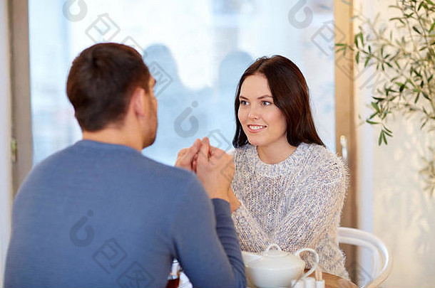 餐厅里一对幸福的夫妇手牵手喝茶