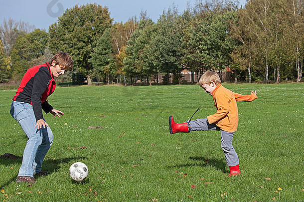 年轻的男孩玩足球女人