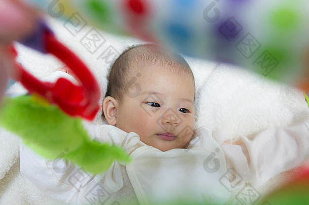 关闭月出生亚洲可爱的婴儿玩玩健身房玩具白色床上背景选择焦点